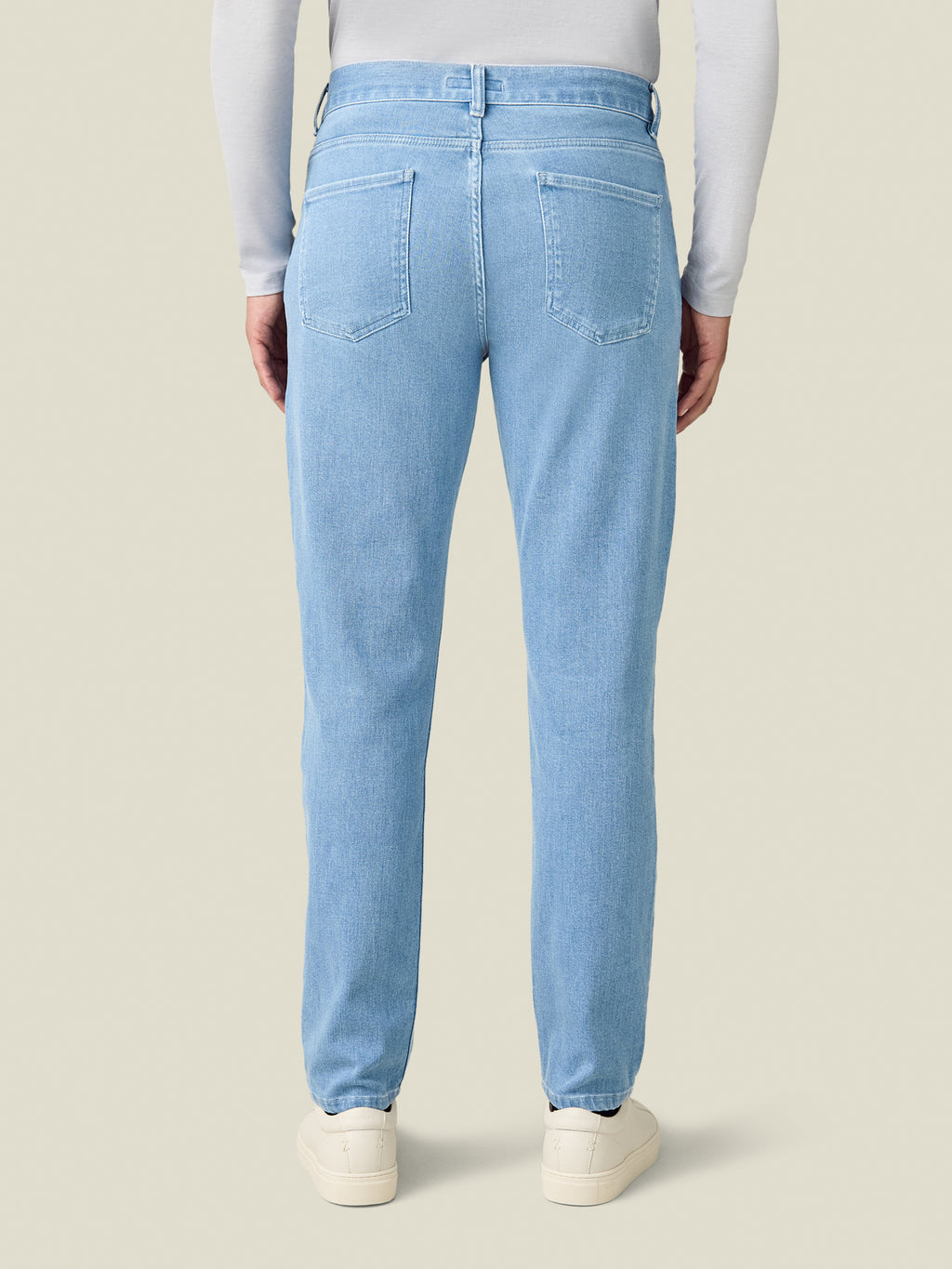 Back view of a model wearing the Luca Faloni Cashmere Denim Jeans in light blue against a plain background.