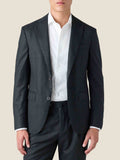 A front view of a model wearing the Charcoal Grey Wool Suit, paired with a white collared shirt.