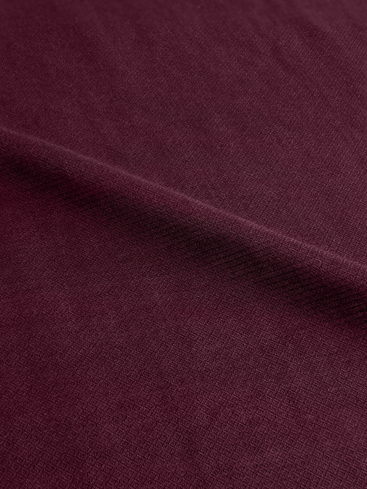 A close-up of the Luca Faloni Silk-Cashmere Scarf in Burgundy, showing its soft handle and distinctive micro-diamond texture.