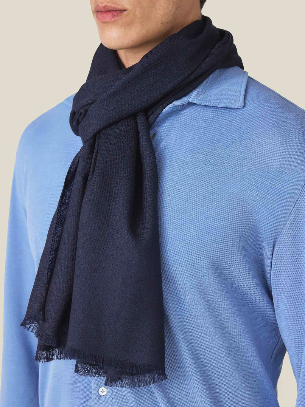 Close-up of a man wearing the midnight blue silk-cashmere scarf styled over a light blue collared shirt.