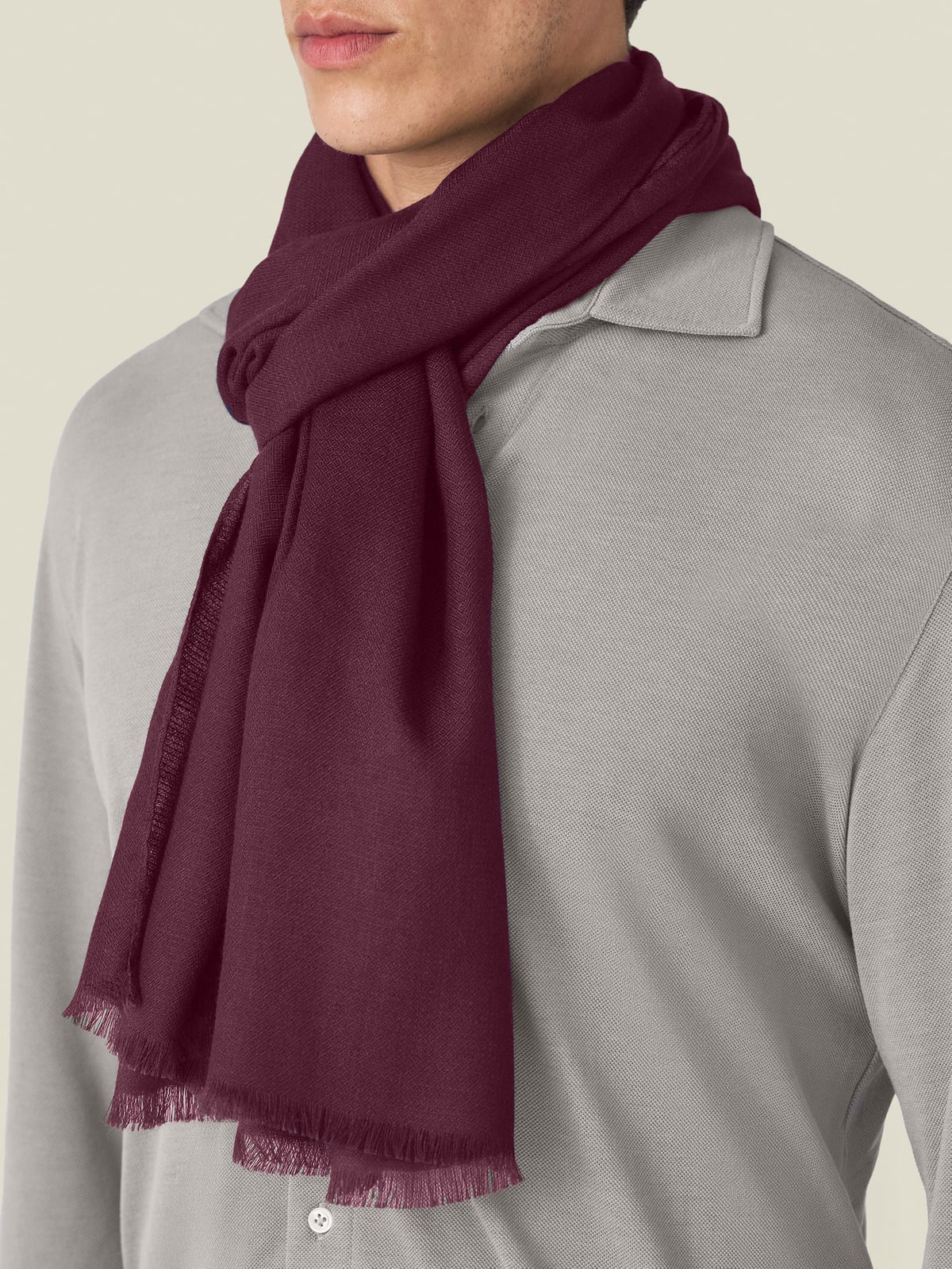 A close-up of the Luca Faloni Silk-Cashmere Scarf in Burgundy, showing its soft texture and drape over a grey collared shirt.