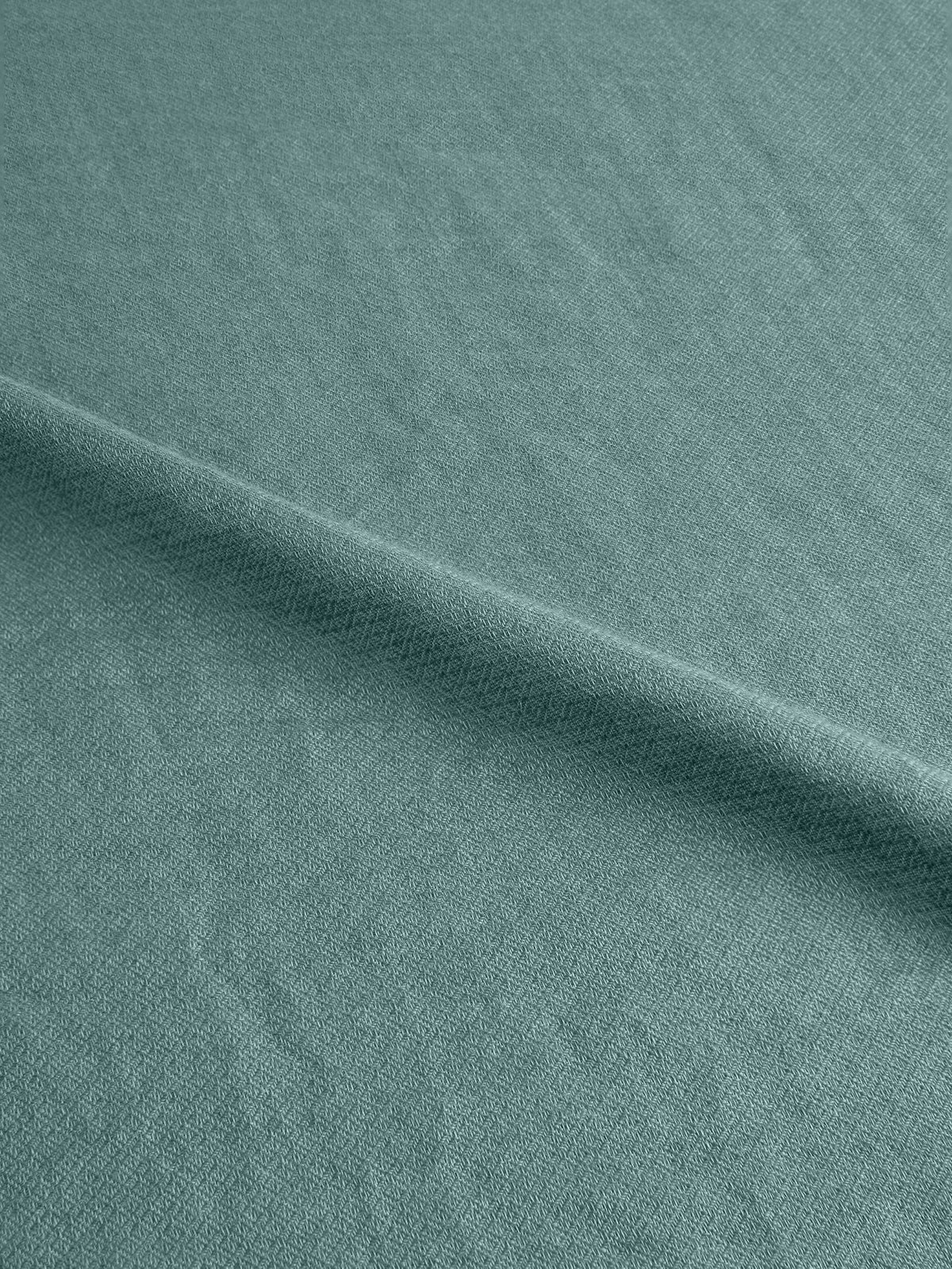 A detailed shot of the teal Silk-Cashmere Scarf's fabric, highlighting its soft and intricate micro-diamond weave.