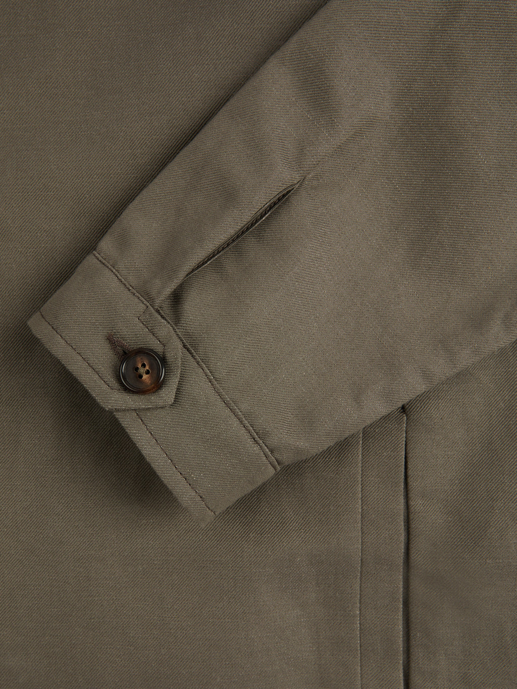 A close-up detail shot of the single horn button cuff on the Nocciola Brown Linen Bomber Jacket.