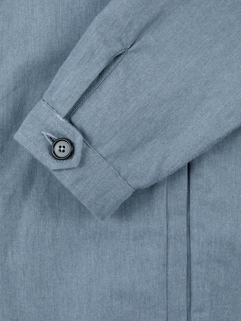 Detail of the single horn button cuff on the French Blue Linen-Cotton Bomber Jacket, showcasing the fabric texture.