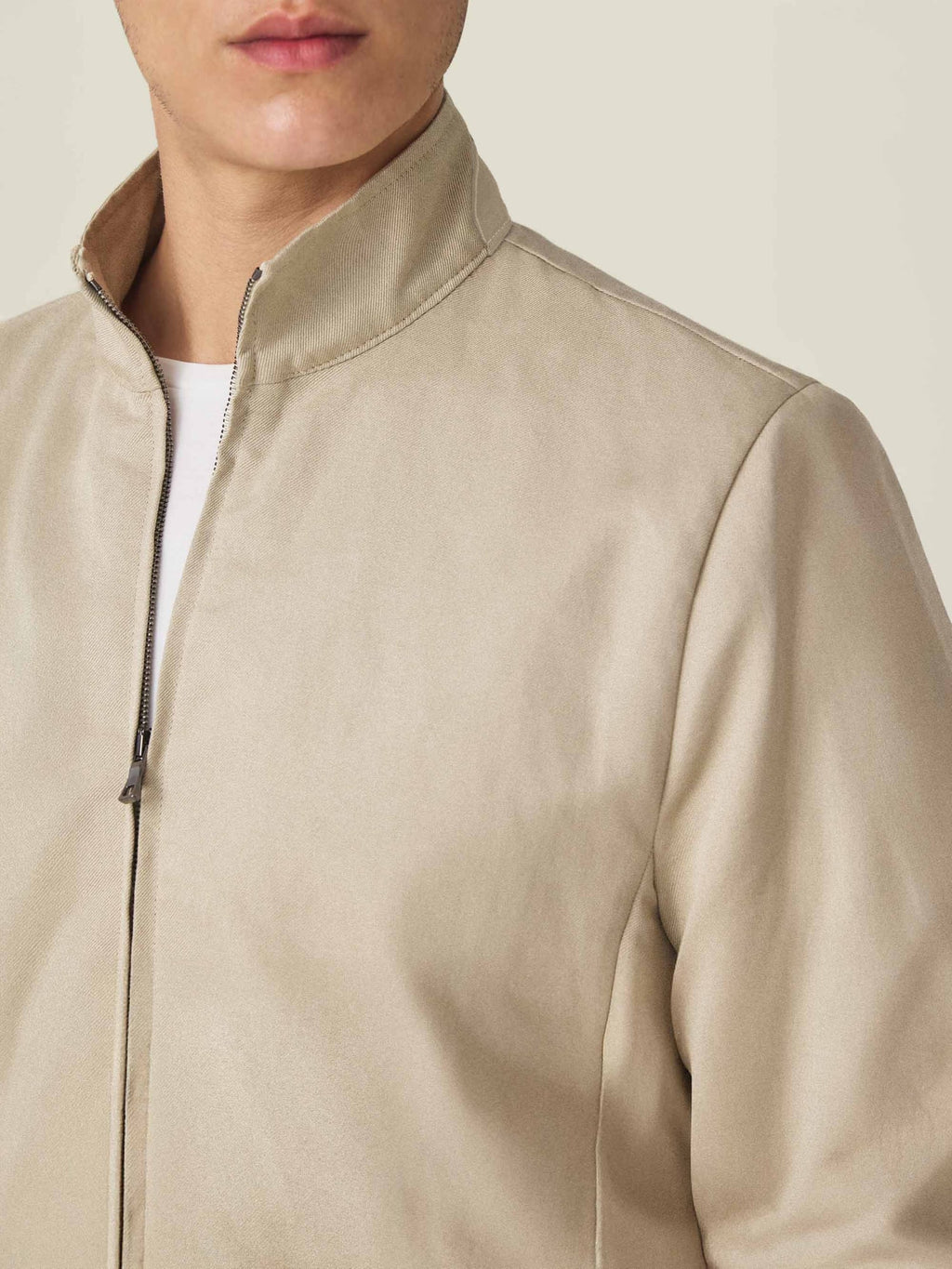 Close-up of the collar detail on the Luca Faloni Linen Bomber Jacket in sand, worn by a model.