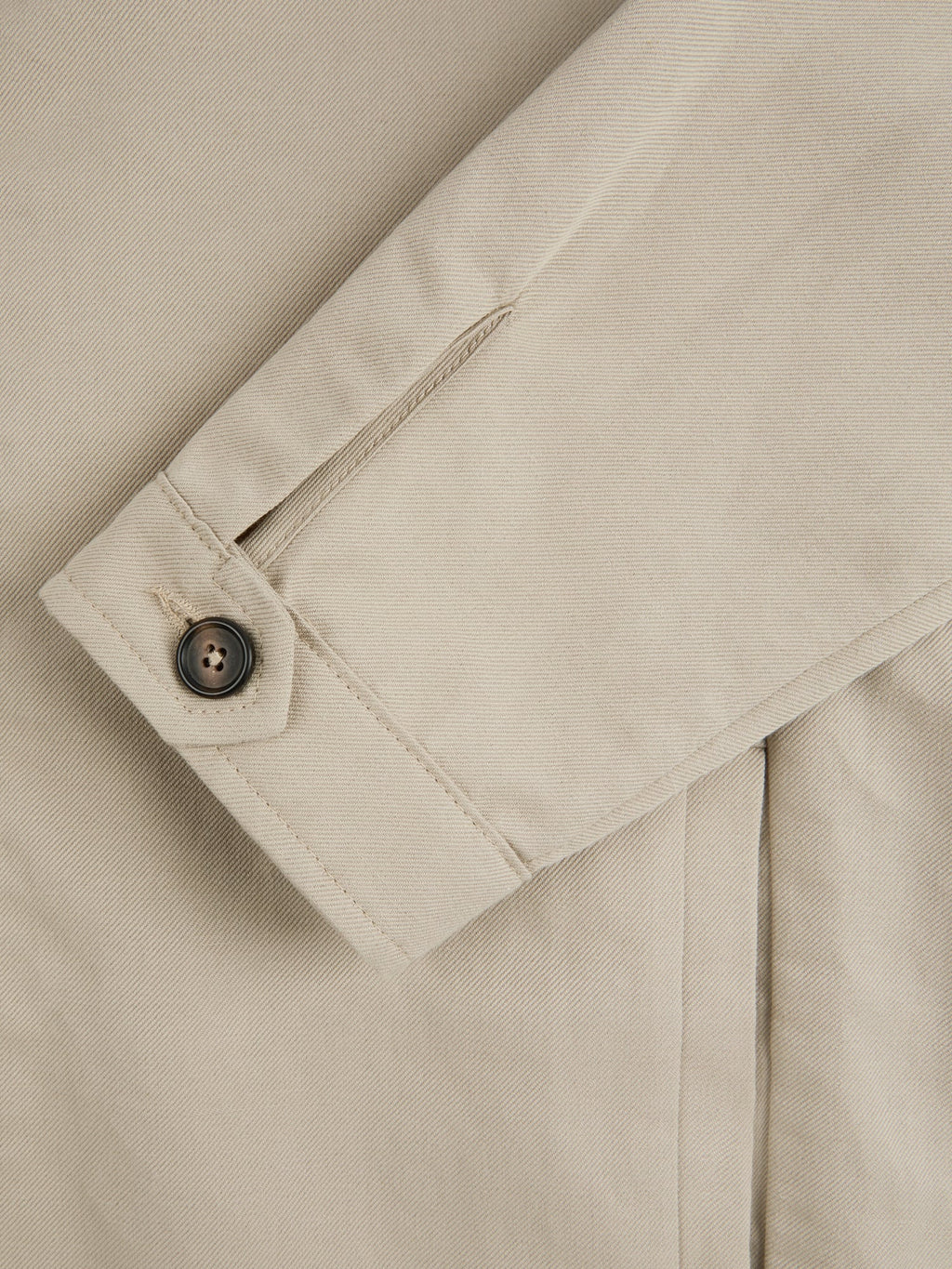 Close-up of the single horn button cuff on the Sand Linen Bomber Jacket, highlighting the texture of the linen-cotton fabric.