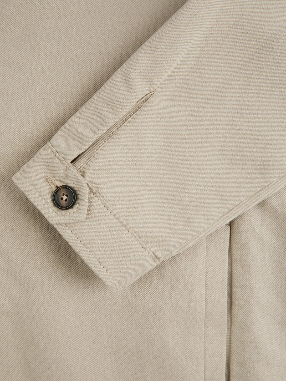 Close-up of the single horn button cuff on the Sand Linen Bomber Jacket, highlighting the texture of the linen-cotton fabric.