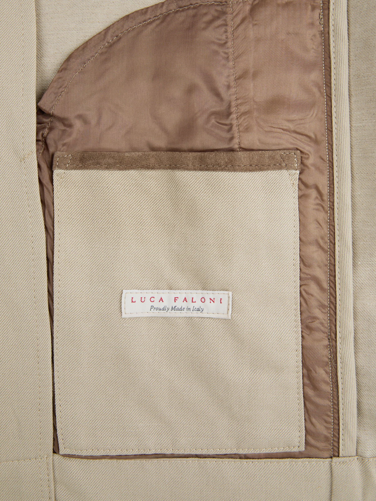 A close-up of the inner pocket of the Sand Linen Bomber Jacket, featuring a suede trim and the Luca Faloni brand label.