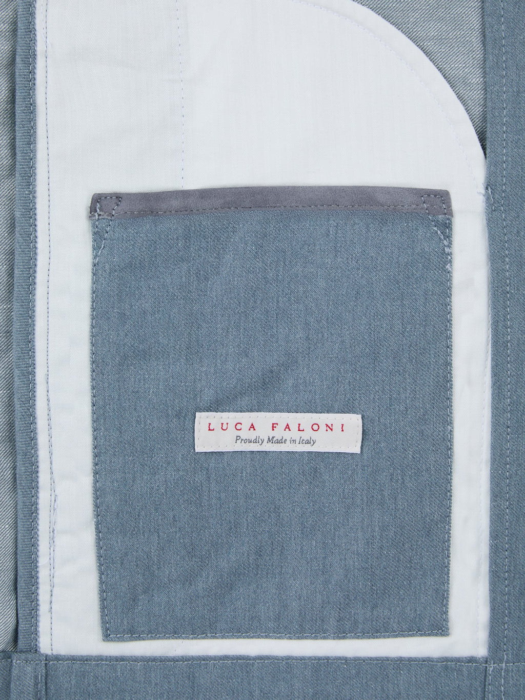 Detail of the internal pocket on Luca Faloni's French Blue Linen Bomber Jacket, with suede insert and Made in Italy label.