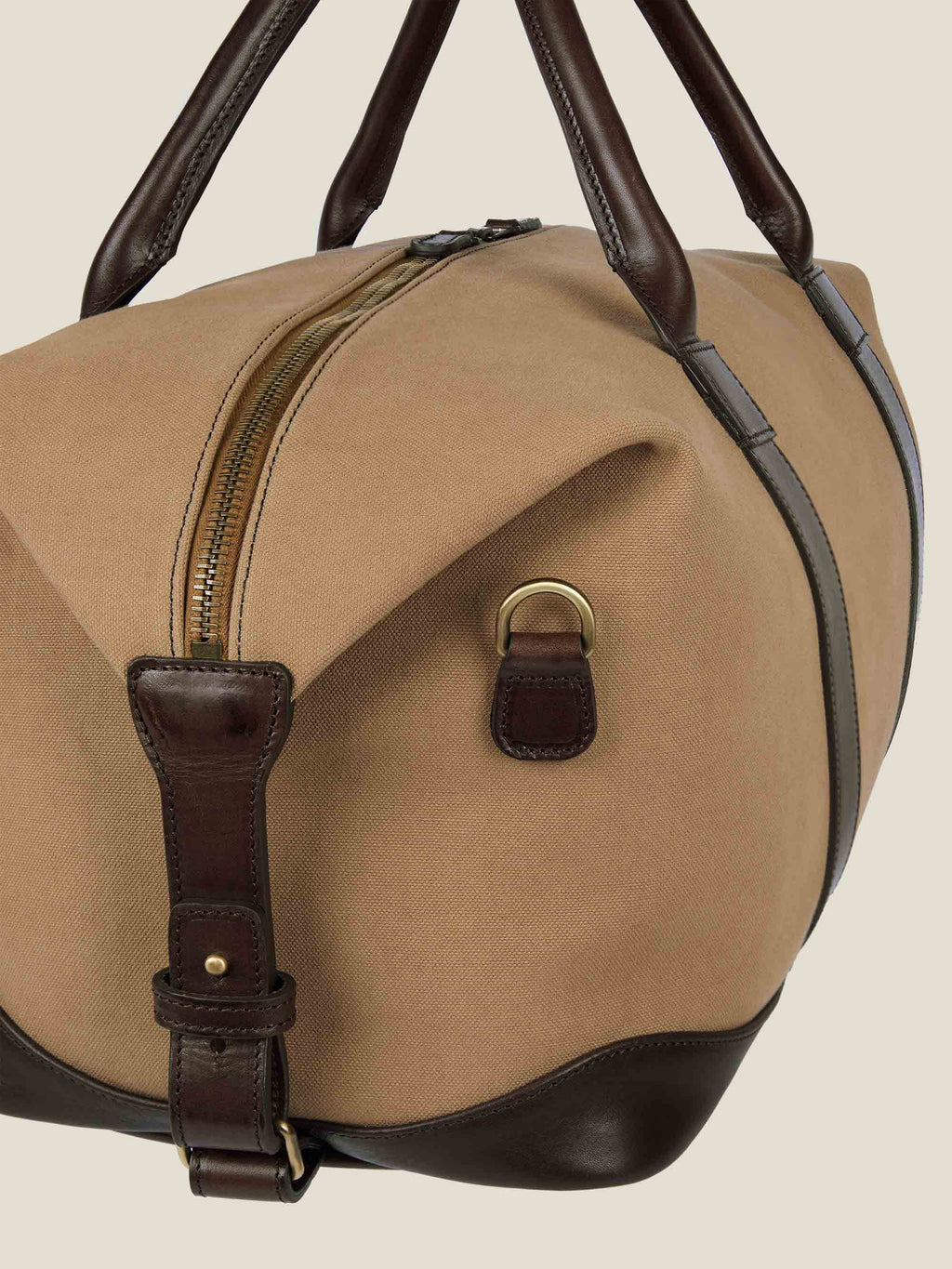 A close-up of the Caramel Brown Canvas Bag, detailing the dark brown leather handles, trim, and brass hardware.