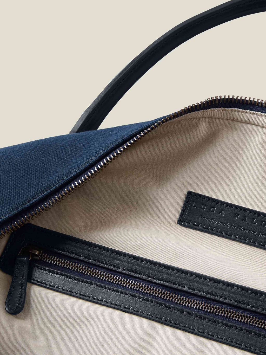 Close-up of the Luca Faloni midnight blue Canvas Bag's interior, with its natural canvas lining and leather zip pocket.