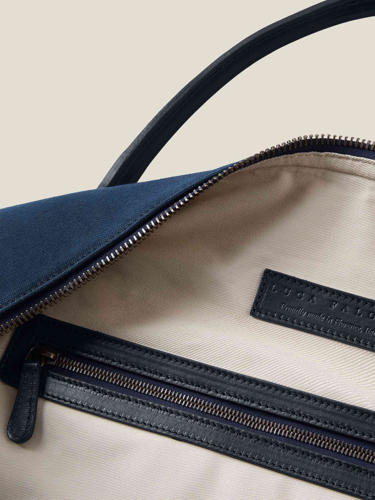 Close-up of the Luca Faloni midnight blue Canvas Bag's interior, with its natural canvas lining and leather zip pocket.