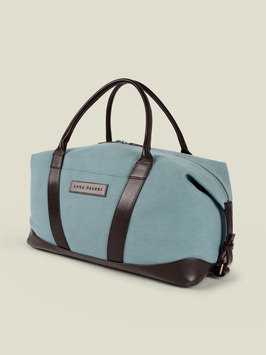 Studio shot of the Luca Faloni Canvas Bag in French Blue with dark brown leather handles, trim, and base.