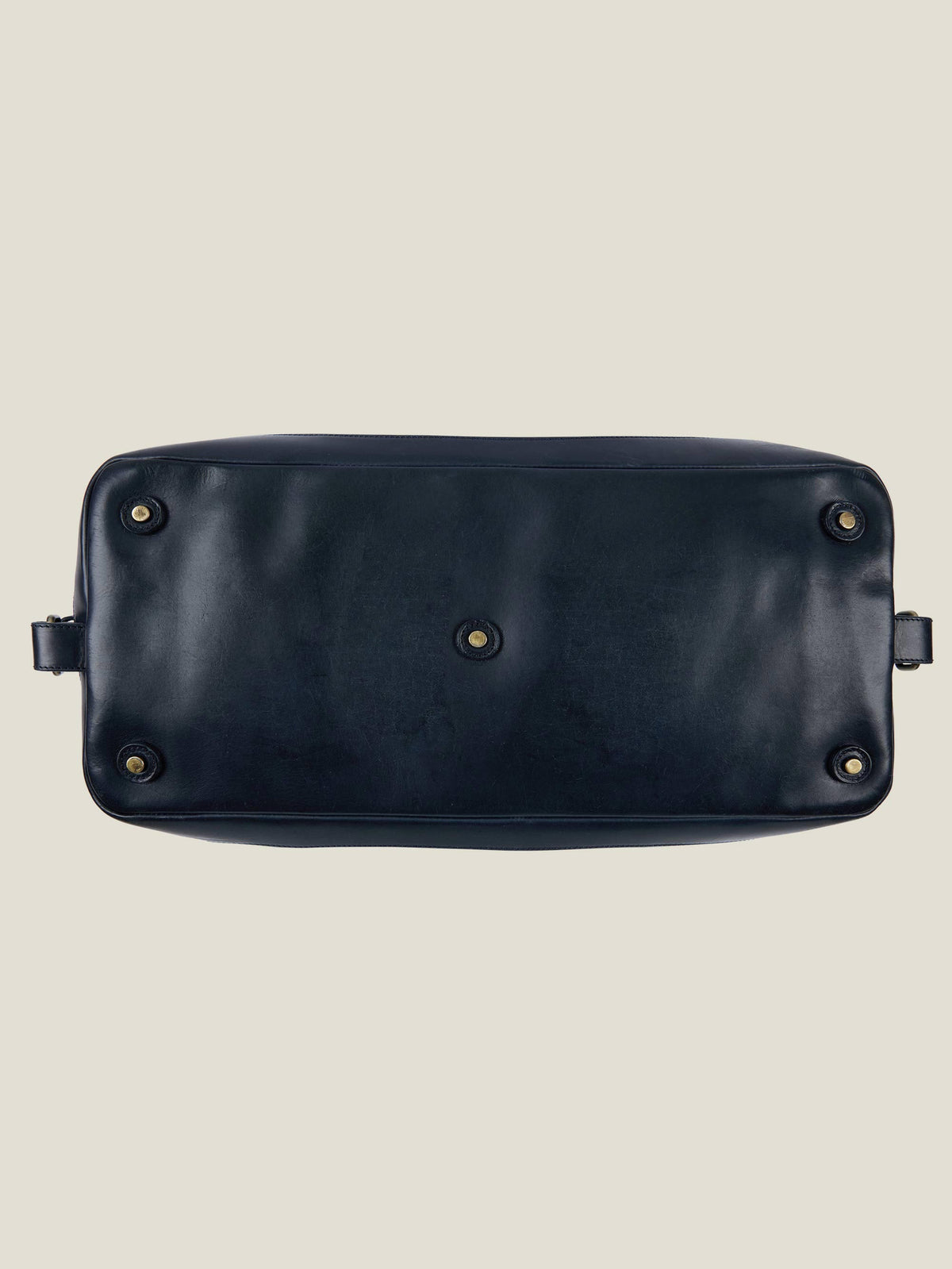 Underside view of the Midnight Blue Canvas Bag, detailing the protective metal feet on the durable leather base.