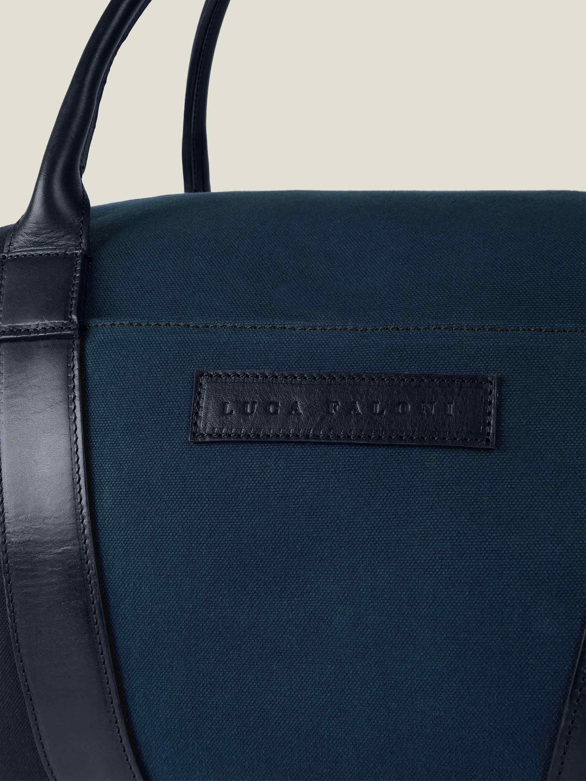 Detail shot of the Midnight Blue Canvas Bag, showcasing the fine canvas texture and the embossed leather Luca Faloni logo.