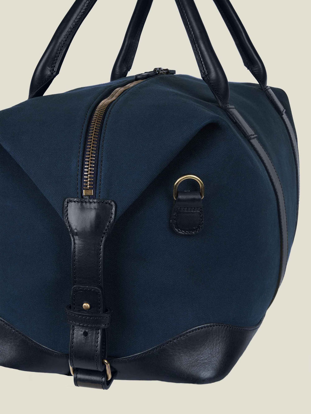 A close-up of the Luca Faloni Canvas Bag in Midnight Blue, detailing the leather handles, side trim, and brass hardware.