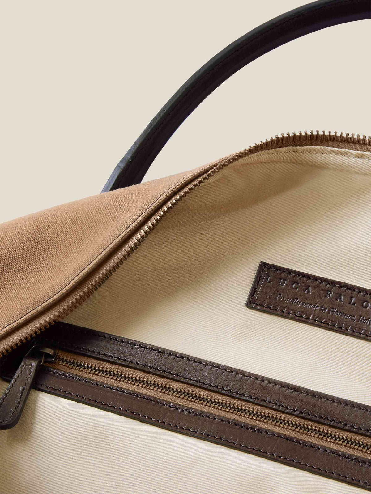 Interior of the caramel brown Canvas Bag showing the natural canvas lining, leather-trimmed zip pocket and embossed logo.