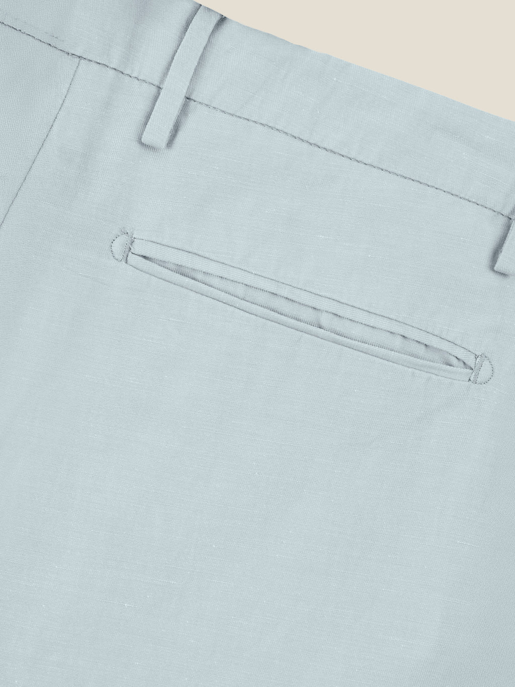 Close-up of the jetted back pocket and belt loop detail on the Light Blue Linen Cotton Trousers.