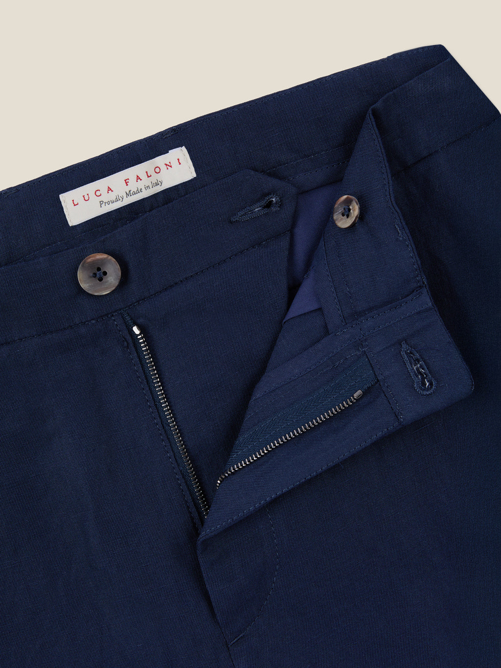 Close-up of the Midnight Blue Linen Cotton Trousers' waistband, showing the zip fly, horn button closure, and brand label.