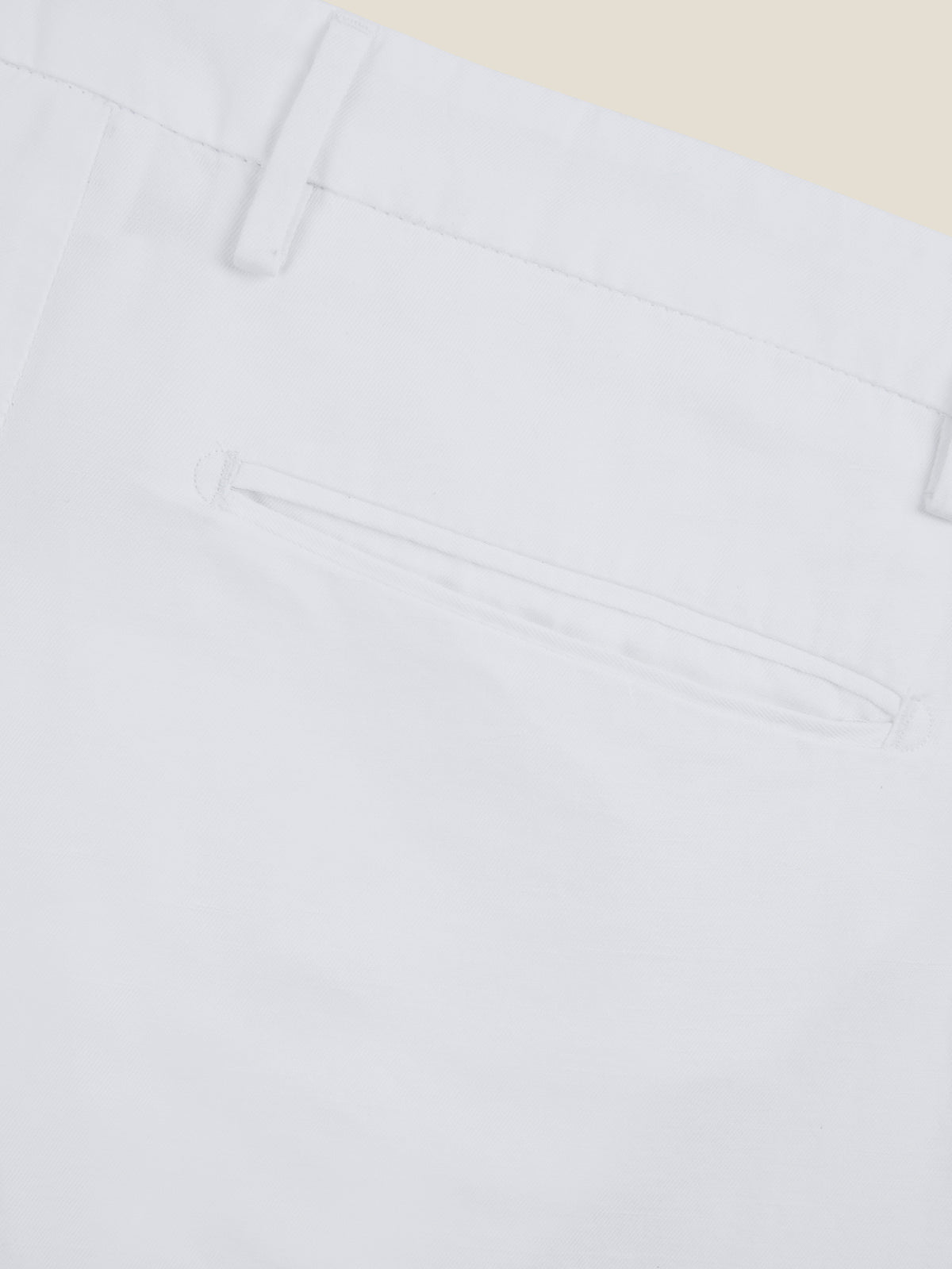 Close-up detail of the back welt pocket and belt loop of the white Linen Cotton Trousers.