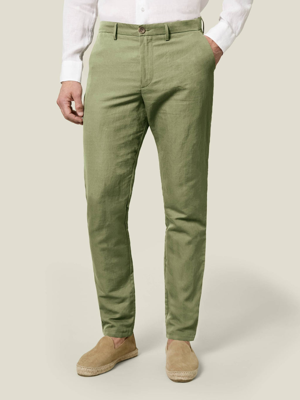 Front view of a model wearing Luca Faloni's Sage Green Linen Cotton Trousers with a white shirt and espadrilles.