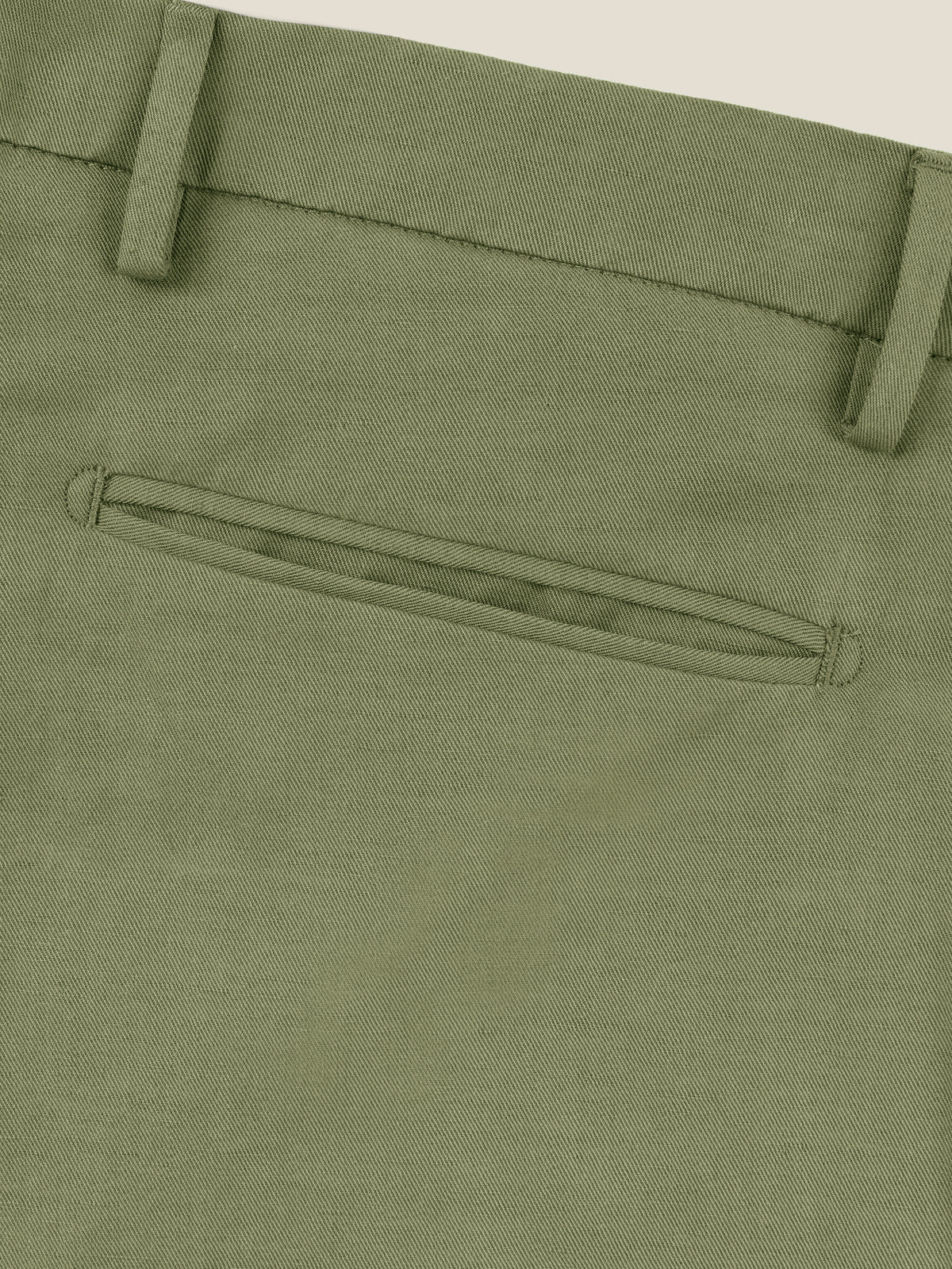Close-up of the back welt pocket and waistband of the Sage Green Linen Cotton Trousers.