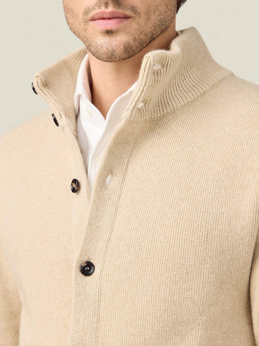 A close-up detail shot of the Oatmeal Cashmere Bomber, highlighting the ribbed funnel collar and horn buttons.