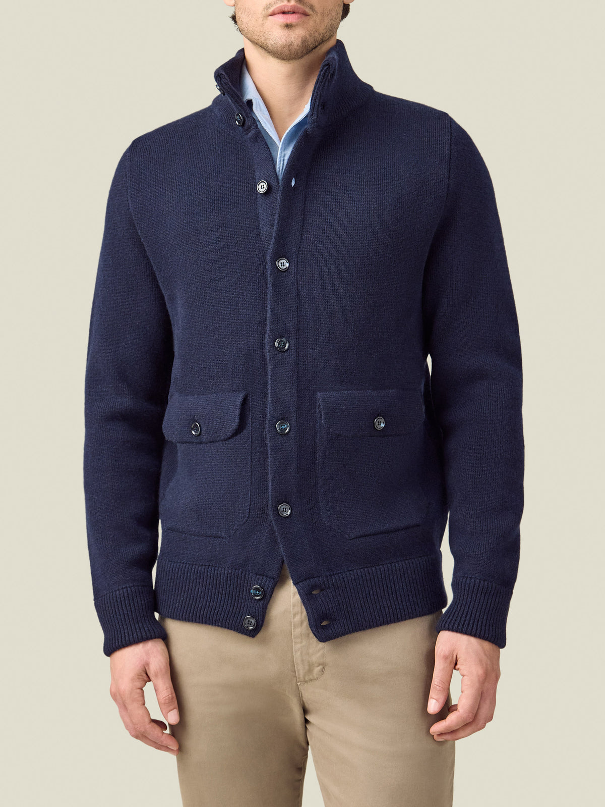A front view of a model wearing the Luca Faloni Cashmere Bomber in Midnight Blue with a light blue shirt and khaki trousers.