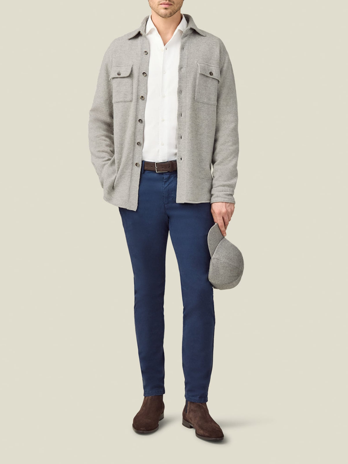 A model wears the Luca Faloni Cashmere Overshirt in Light Grey, styled over a white shirt with blue trousers and brown boots.