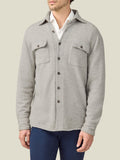 Front view of a model wearing the Luca Faloni Cashmere Overshirt in Light Grey, layered over a white shirt and blue trousers.
