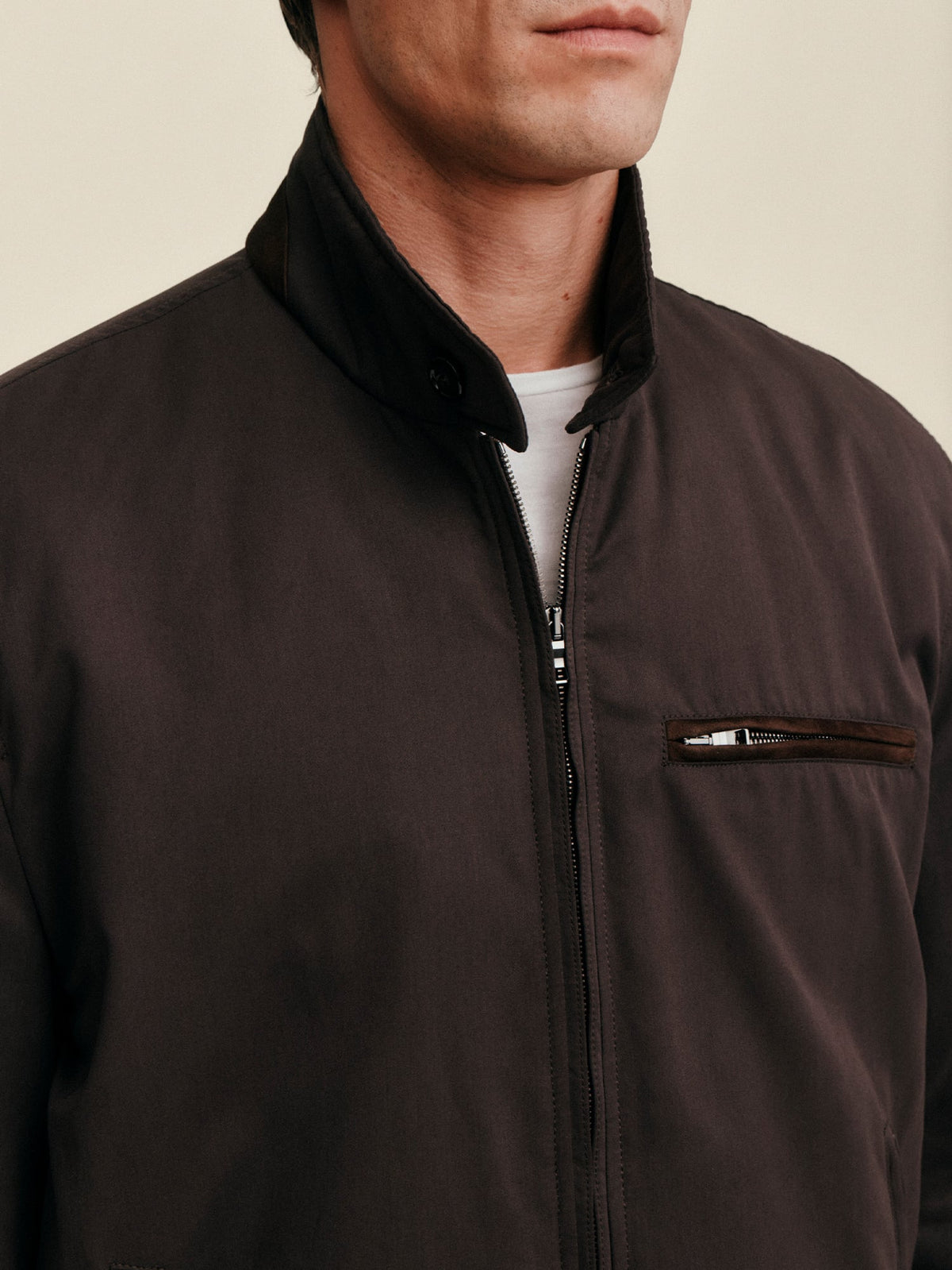 Close-up of a model wearing the Luca Faloni City Jacket in Chocolate Brown, showing the suede collar and zip details.
